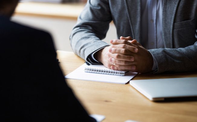 business meeting hands clasped on table