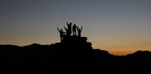 ethical leadership and Effective Leadership as portrayed by people standing on a rock with their fists in the air Participative Leadership